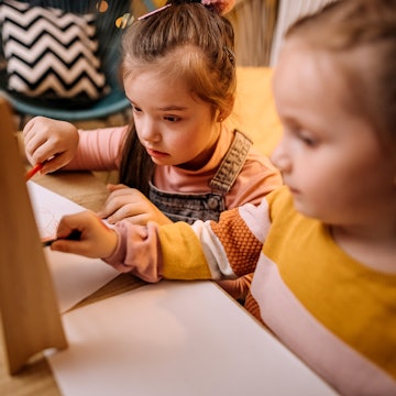 Two children playing with puzzles testing for ASD. A new study suggests that brain scans taken in th...