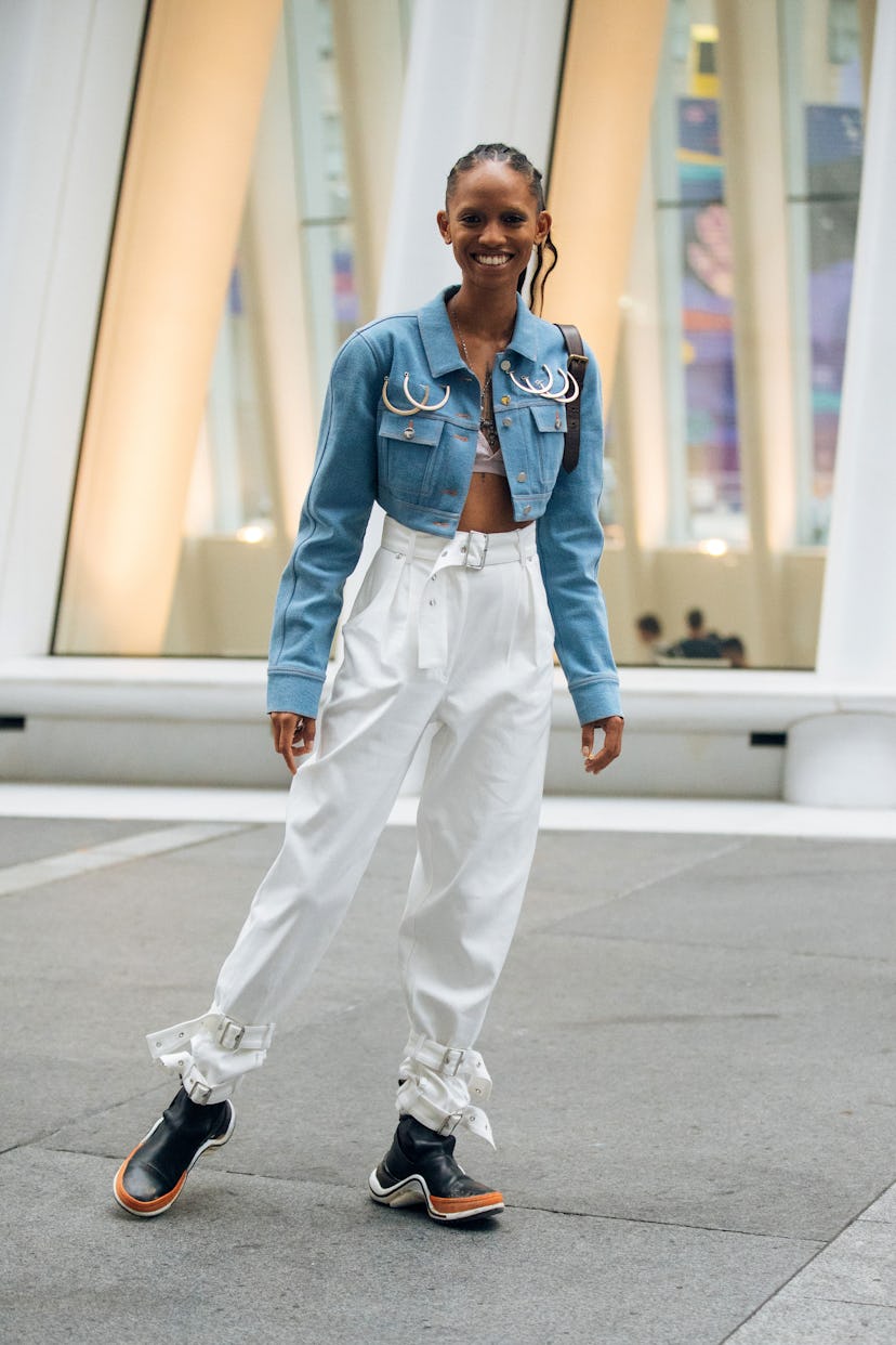 NEW YORK, NY - SEPTEMBER 08: Model Adesuwa Aighewi in a cropped blue jacket with rings, white pants,...