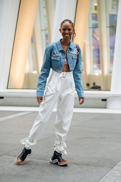 NEW YORK, NY - SEPTEMBER 08: Model Adesuwa Aighewi in a cropped blue jacket with rings, white pants,...