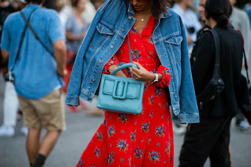 COPENHAGEN, DENMARK - AUGUST 09: A guest wearing denim jacket, red dress, blue bag is seen outside S...