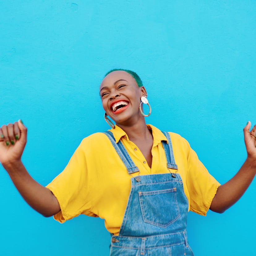 Young woman dancing her heart out, embracing the April 25, 2022 weekly horoscope for her zodiac sig...