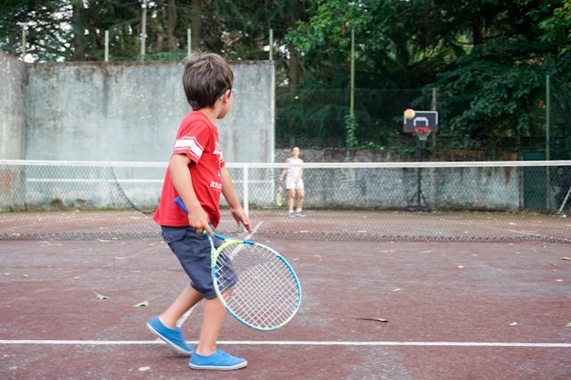 Boy playing tennis with his mother, Oleiros, A Coruna, Galicia, Spain