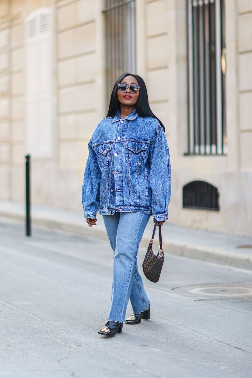 PARIS, FRANCE - MARCH 07: Carrole Sagba @linaose wears sunglasses, a blue denim jacket, blue jeans f...