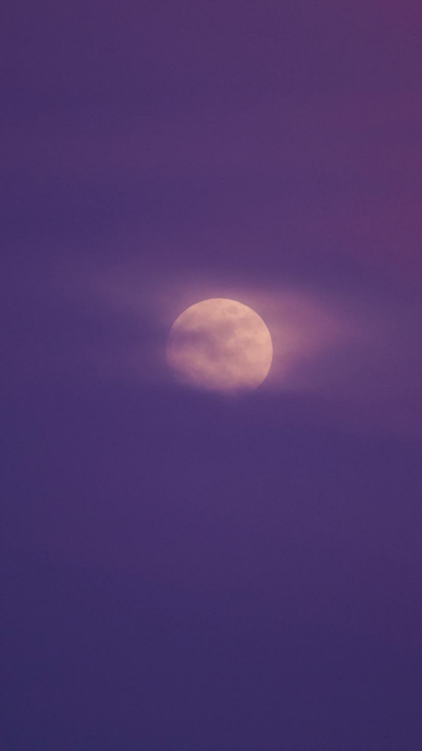 Nighttime sky with clouds and bright full moon. The April full "Pink" moon peaks on Apr. 16.