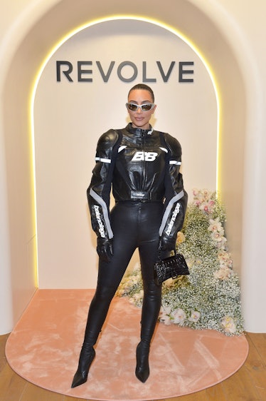 Kim Kardashian at the Revolve Social Club VIP Opening  in a black leather racing jacket and pants