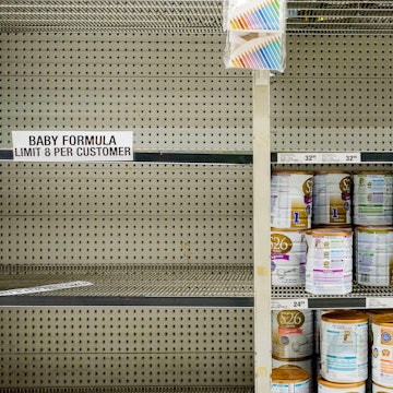 A grocery store shelf with limits on how many cans of powdered infant formula a customer can buy. Am...