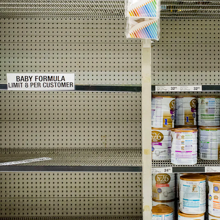 A grocery store shelf with limits on how many cans of powdered infant formula a customer can buy. Am...