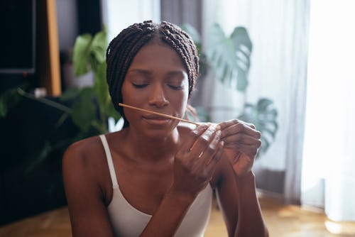 A woman smells incense to destress from her may 11 zodiac sign daily horoscope for 2022.