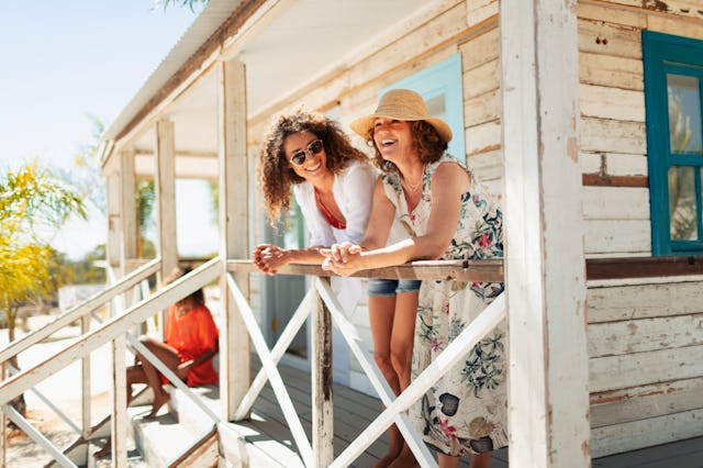 Mother and adult daughter relaxing on sunny beach hut patio