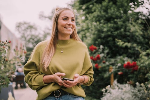 A woman walks in a rose garden on her phone. These zodiac signs will be least affected by the May 20...