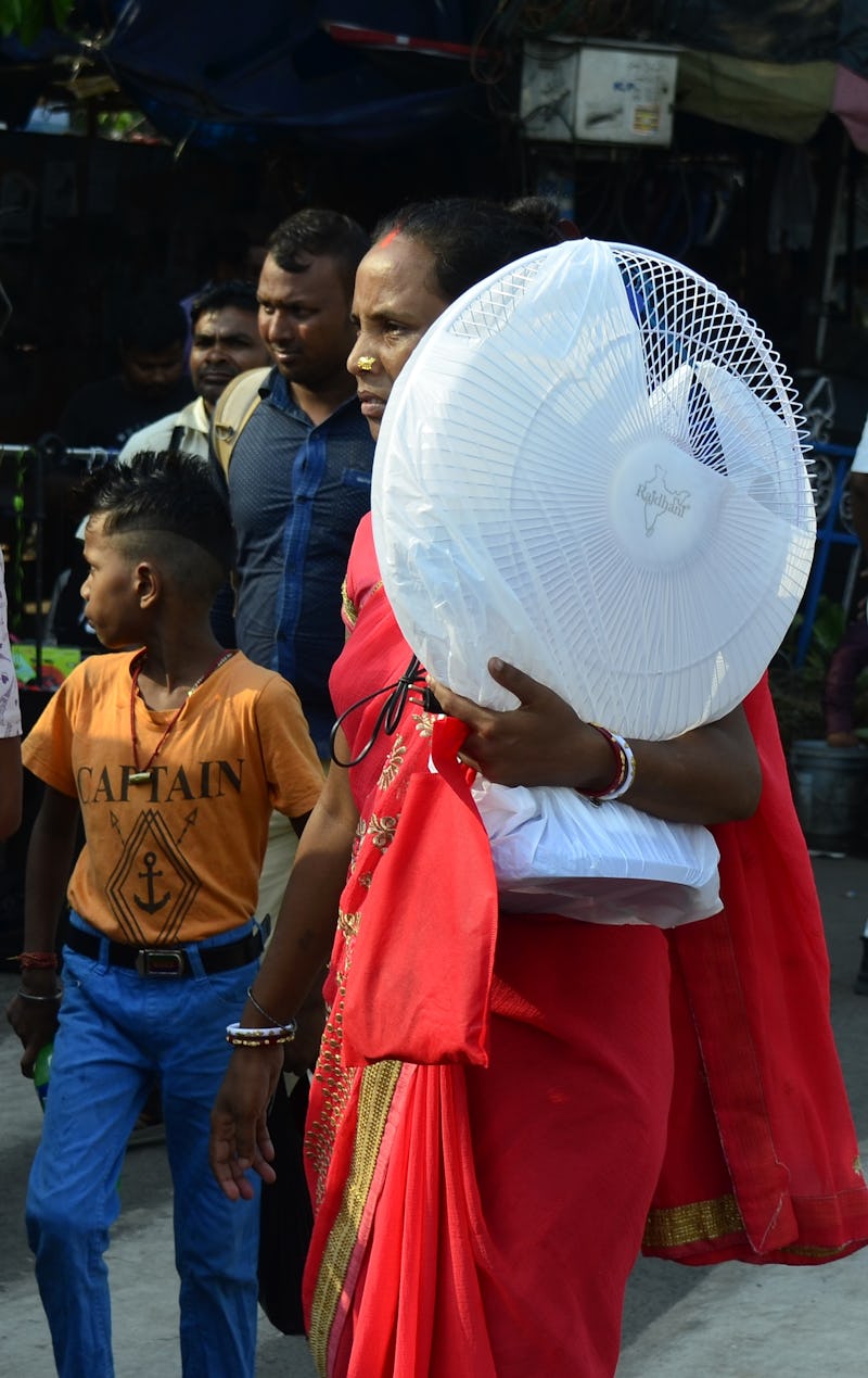A woman carries a fan on her shoulder amid heatwave in Kolkata, India, 02 May, 2022.  (Photo by Indr...