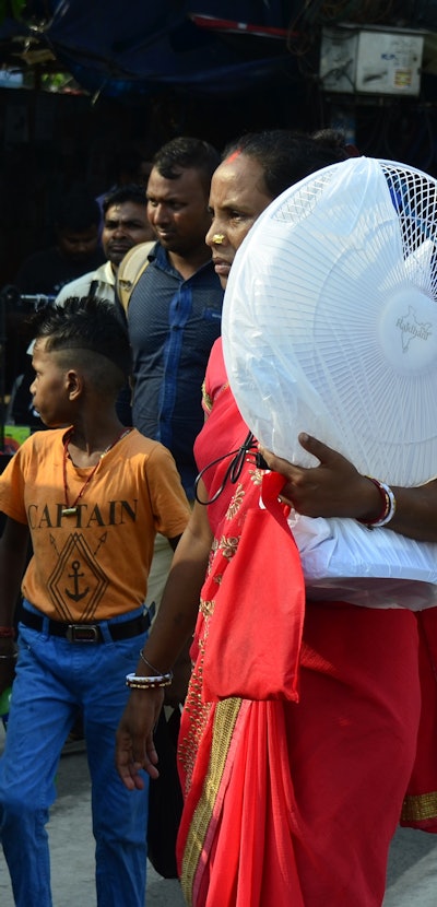 A woman carries a fan on her shoulder amid heatwave in Kolkata, India, 02 May, 2022.  (Photo by Indr...