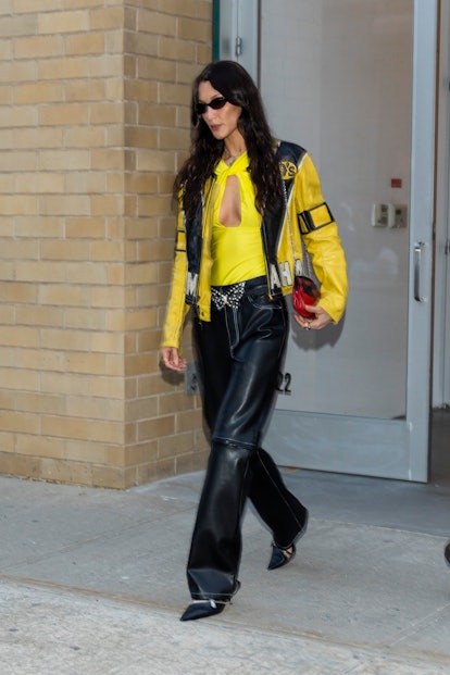 Bella Hadid in yellow jacket, leather pants, and statement belt in NYC