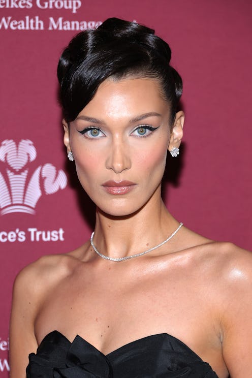 Bella Hadid wears a black midi dress and opera gloves on the red carpet