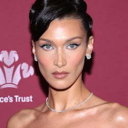 Bella Hadid wears a black midi dress and opera gloves on the red carpet