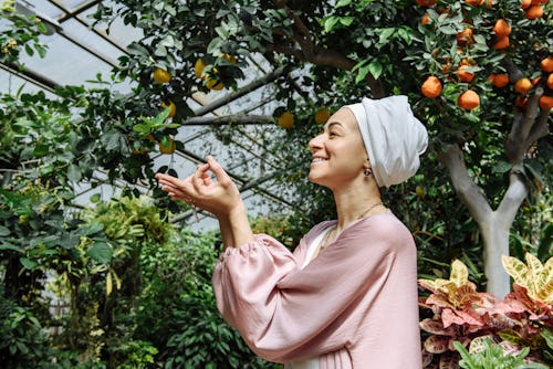 A woman wearing hijab in a fruit orchard. Here's your May 16 zodiac sign daily horoscope.