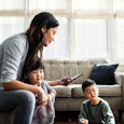 Mother using smartphone with children present