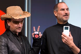 Bono, left, of the band U2, and Apple Computers Inc. Chief Executive Steve Jobs, right, hold up Appl...
