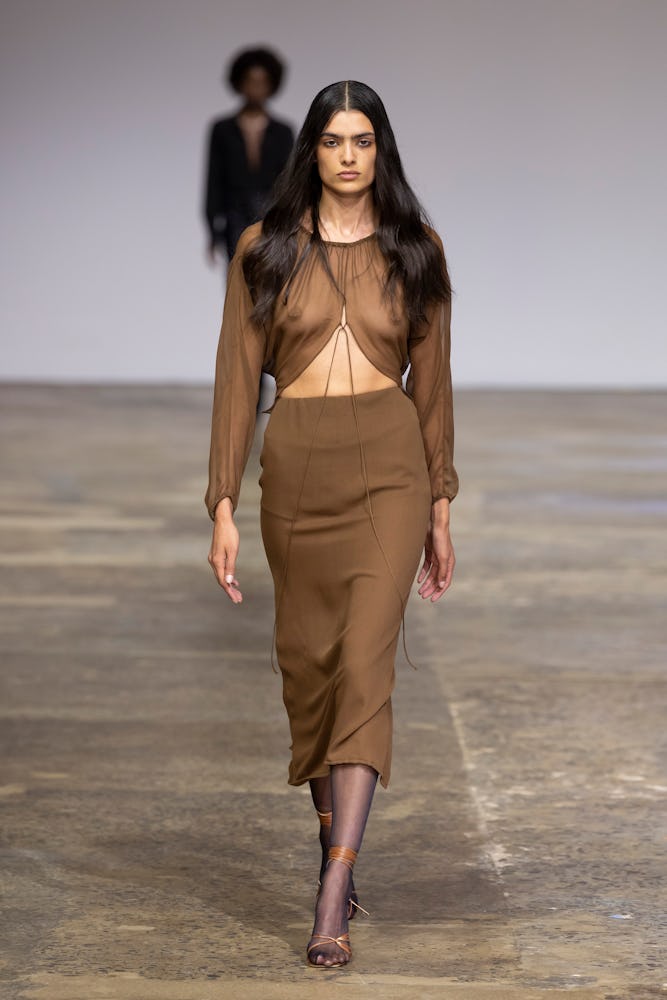 A model walks the runway during the Beare Park show in a light brown minimalist midi skirt with a ma...
