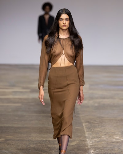 A model walks the runway during the Beare Park show in a light brown minimalist midi skirt with a ma...