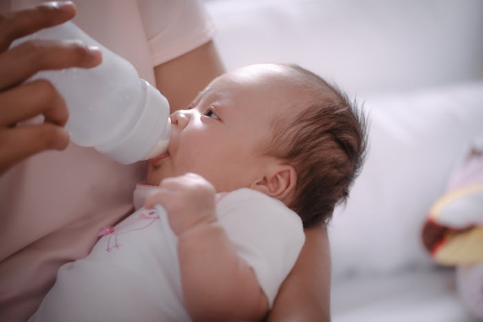 Newborn baby is fed from a bottle.