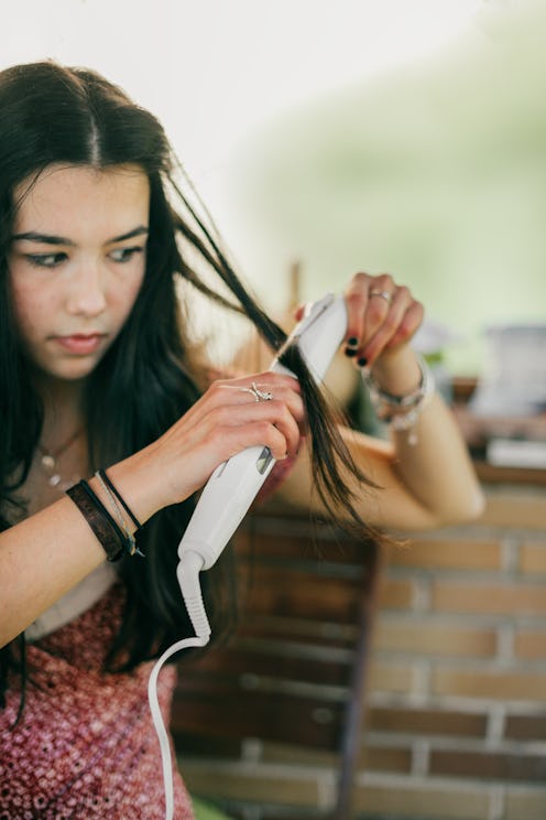 girl using curling iron