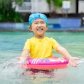 Cute little girl playing in a pool with a bright swimsuit - a new study found that bright neon color...
