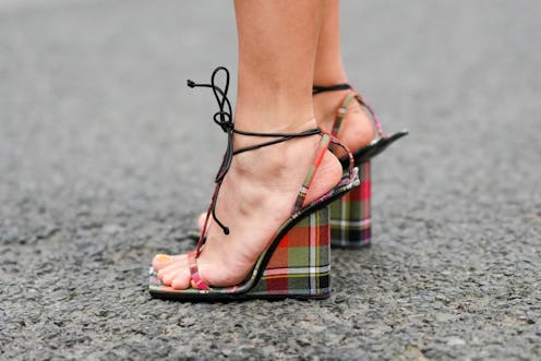 PARIS, FRANCE - MARCH 02: Regina Anikiy wears red / green / black checkered print pattern strappy we...