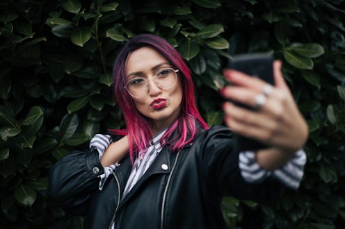 woman with pink hair taking a selfie