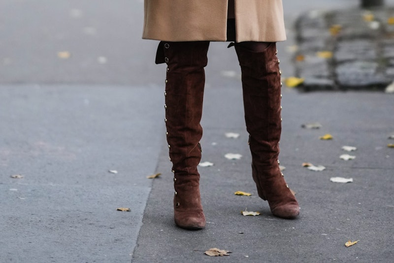 PARIS, FRANCE - NOVEMBER 18: A passerby wears a beige wool long coat, brown suede buttoned waders / ...