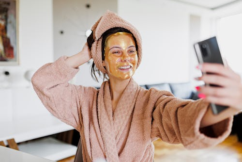 A beautiful woman with sheet mask onto her face taking a selfie. Here's how to add music to an insta...