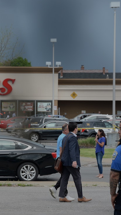 A police officer standing in front of the store in Buffalo where the mass shooting that targeted bla...