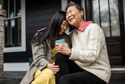 Adult woman hugging mother on front porch, how to tell your family you're pregnant