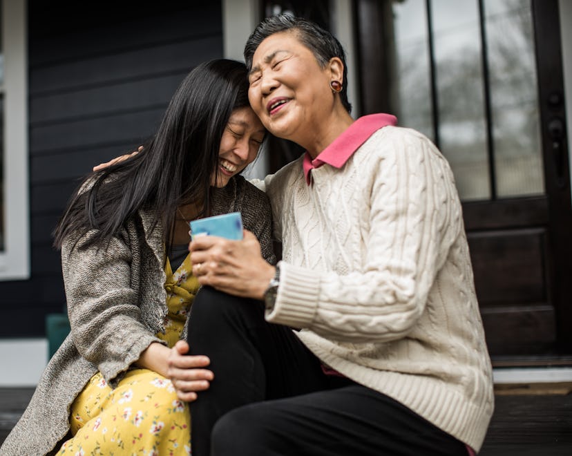Adult woman hugging mother on front porch, how to tell your family you're pregnant