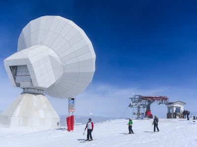 SIERRA NEVADA, SPAIN - MARCH 05:  People ski past the IRAM 30m Radio Telescope at Sierra Nevada sky ...