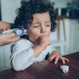 A mother checks her coughing child's temperature. A new study links the omicron variant to rising ca...