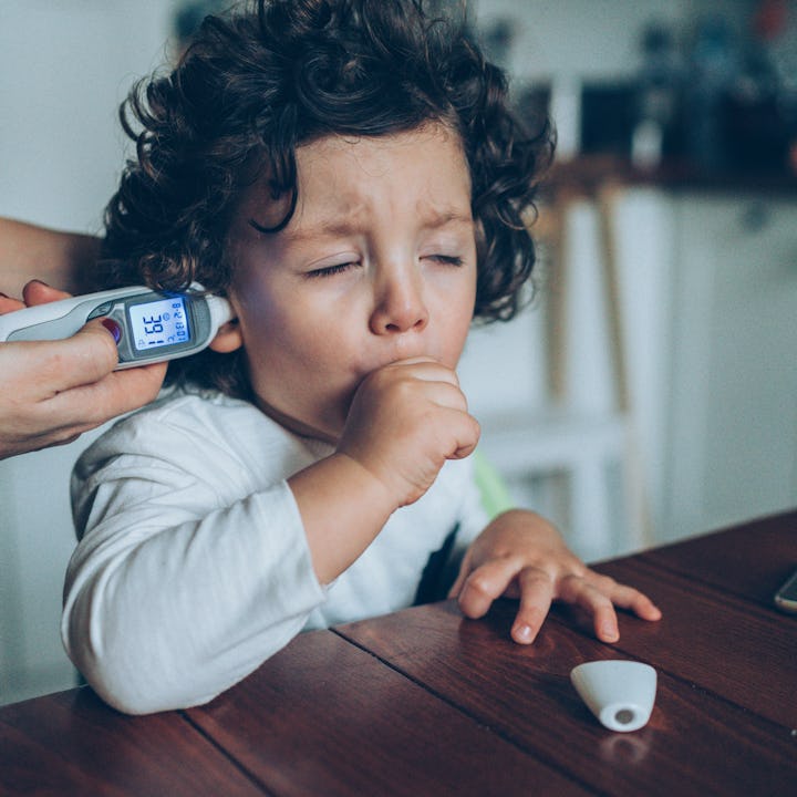 A mother checks her coughing child's temperature. A new study links the omicron variant to rising ca...