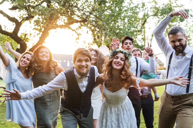 A couple at their wedding with guests wondering how much it costs to attend a wedding in 2022.