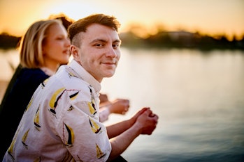 Portrait of a smiling young transgender man watching sunset with his friends