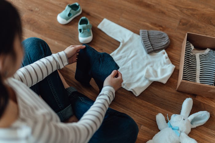 woman folding baby clothes, best apps to sell baby gear