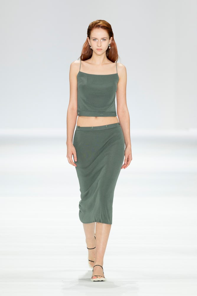 A model walks the runway in a green minimalist midi skirt during the St. Agni show during Afterpay A...