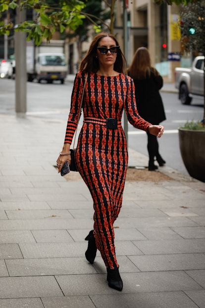 SYDNEY, AUSTRALIA - MAY 13: A guest wearing a red and black pattern maxi dress and a sunglasses at A...
