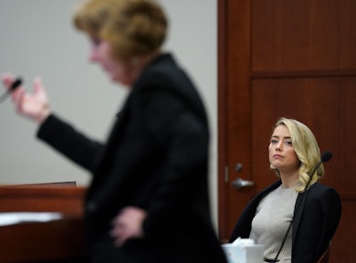 Actor Amber Heard listens as her lawyer Elaine Bredehoft questions her sister Whitney Henriquez (not...
