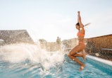 Photo of a young woman jumping in the swimming pool. Here's how gemini season 2022 will affect each ...