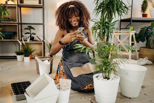 Happy woman photographs a houseplant. Why can't I go live on Instagram? Here are some troubleshootin...