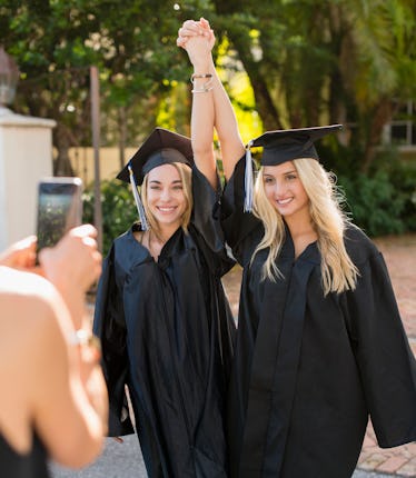 Two best friends take a selfie and use graduation memories quotes for sharing it on Instagram.