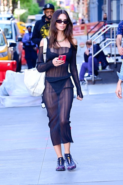 Emily Ratajkowski is seen wearing a black, sheer dress with a thong underneath.