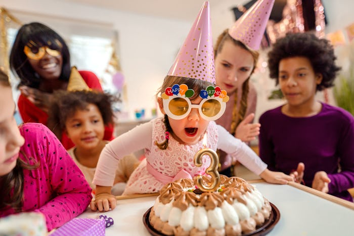 A little girl blowing her candle at her birthday party that's been decorated using these birthday pa...