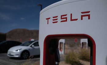 Tesla cars sit at charging stations in Yermo, California, on May 14, 2022. (Photo by Chris Delmas / ...