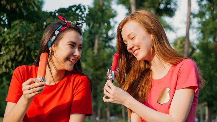 two women eat popsicles as they discuss their sign’s compatibility with gemini